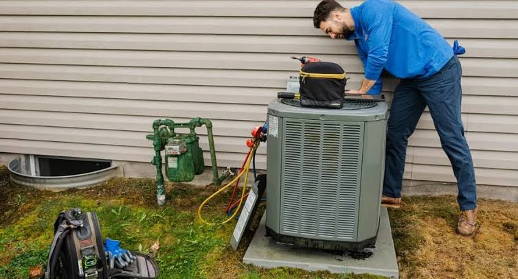 Technician working on a residential outdoor air conditioning system